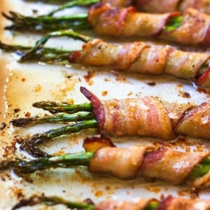 Bacon Wrapped Asparagus Bundles in a parchment-lined sheet pan