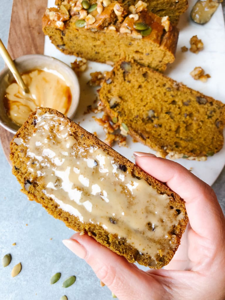 A slice of healthy bread with nuts and seeds spread evenly with a sweet concoction