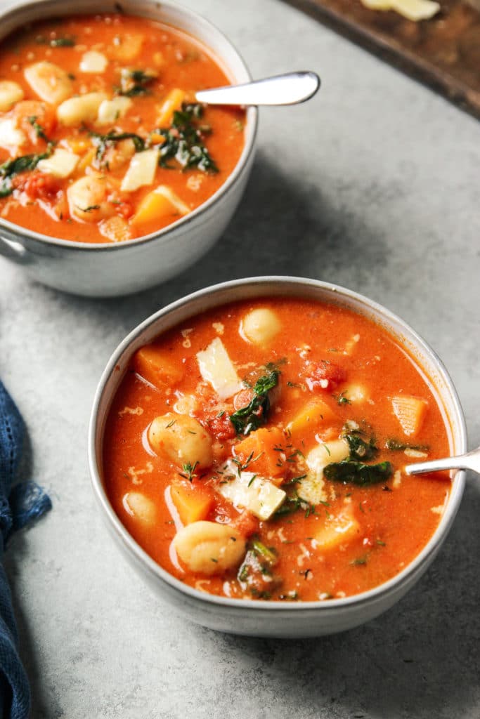 Two bowls of a tomato-based soup 