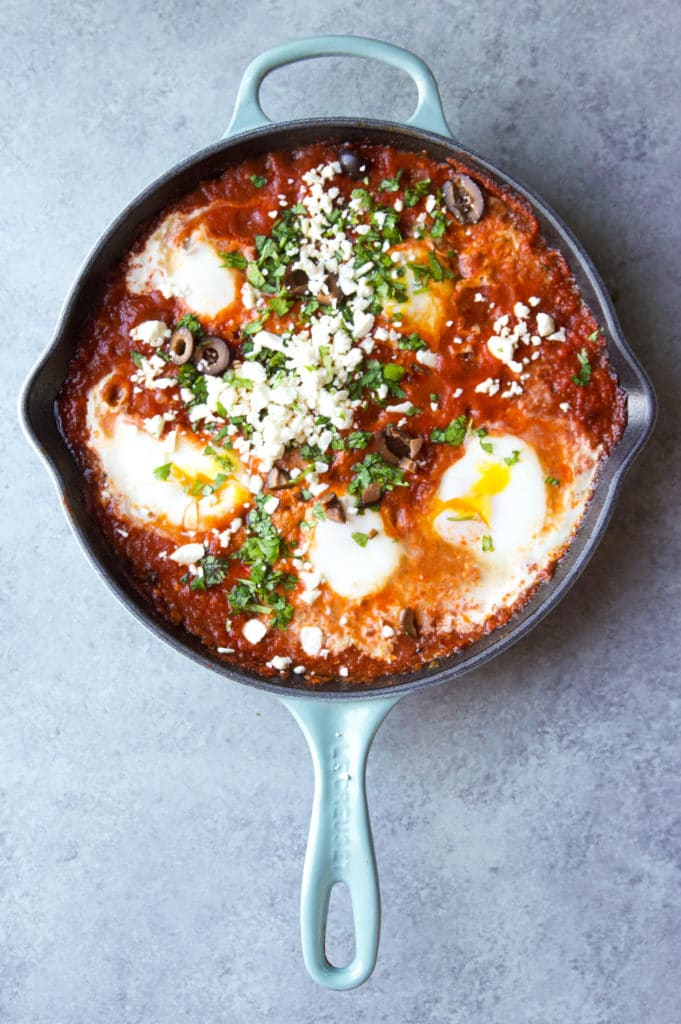 Shakshuka topped with black olives, parsley and feta cheese