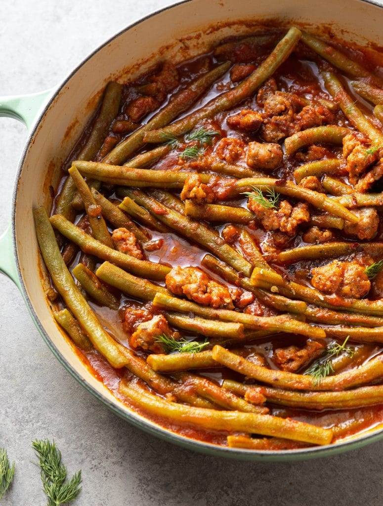 braised green beans with sausage in large skillet