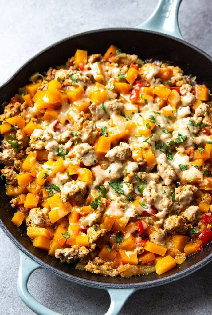 ground turkey and butternut squash skillet, topped with gruyere cheese and fresh cilantro