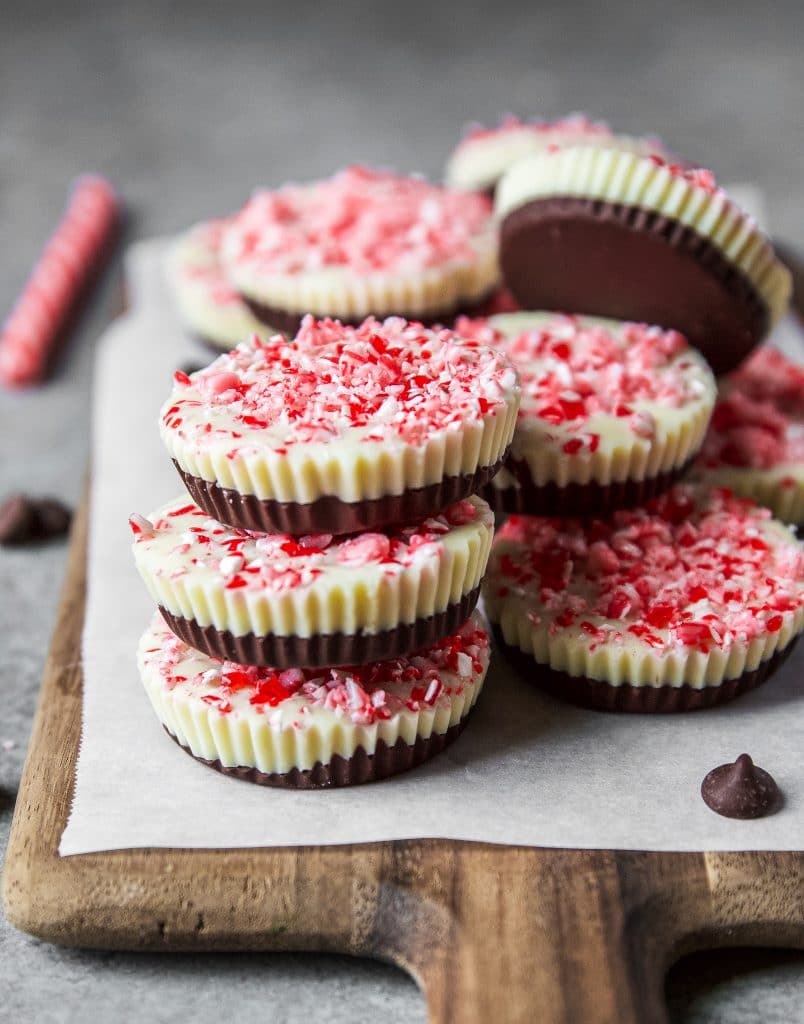 chocolate peppermint cups stacked on top of each other on a wooden board.