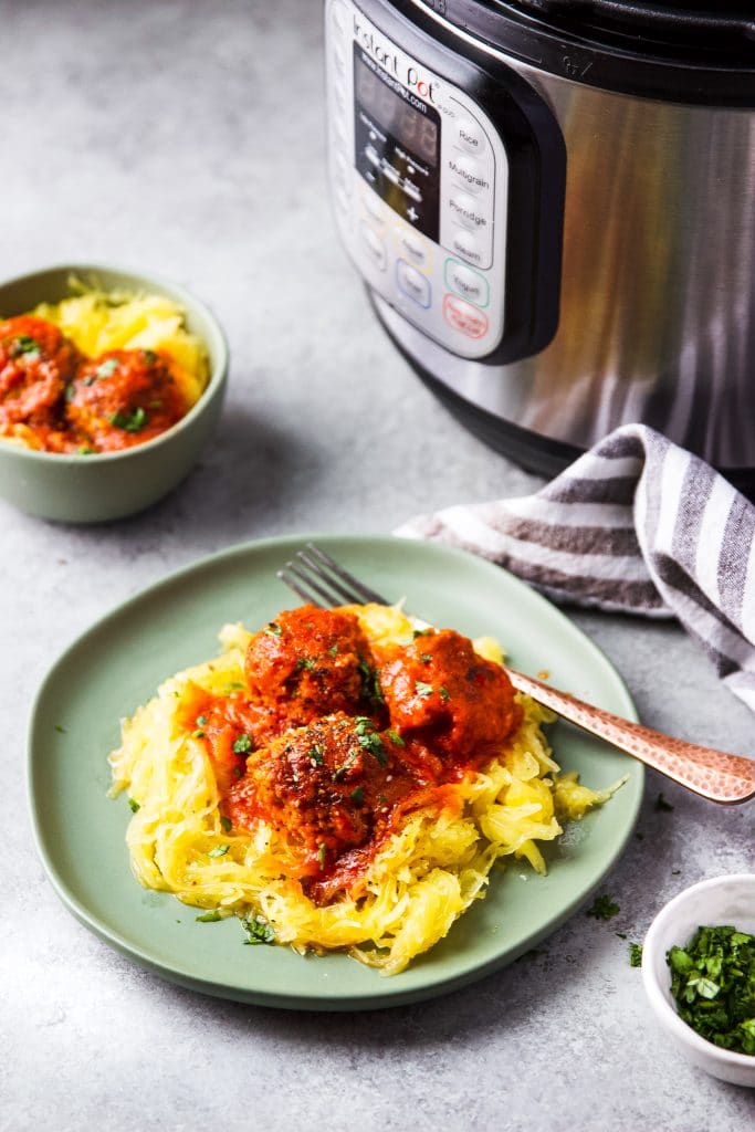 a plate and a small bowl with turkey meatballs and spaghetti squash. An instant pot