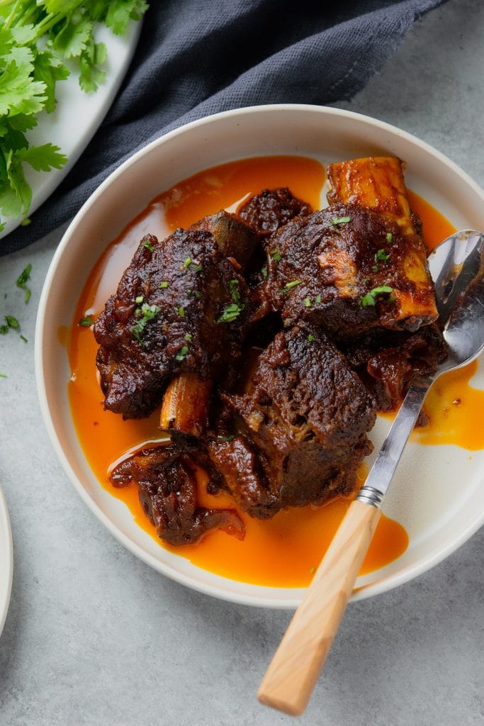 Braised short ribs recipe in oven, served on a plate.
