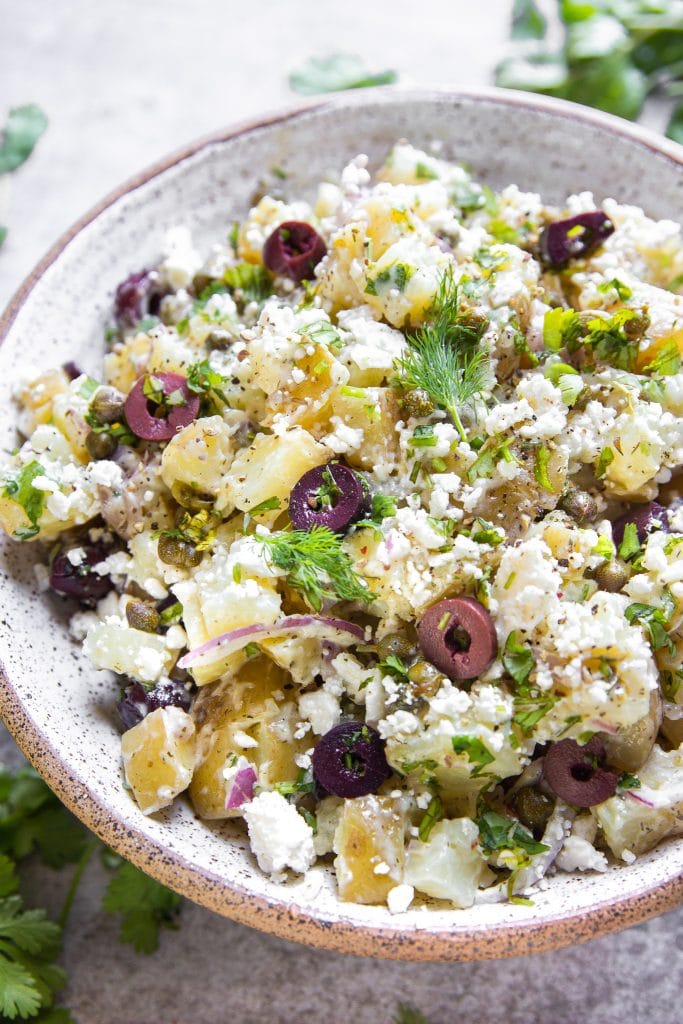 Potato salad with olives, red onions, feta cheese, cilantro, parsley and capers.