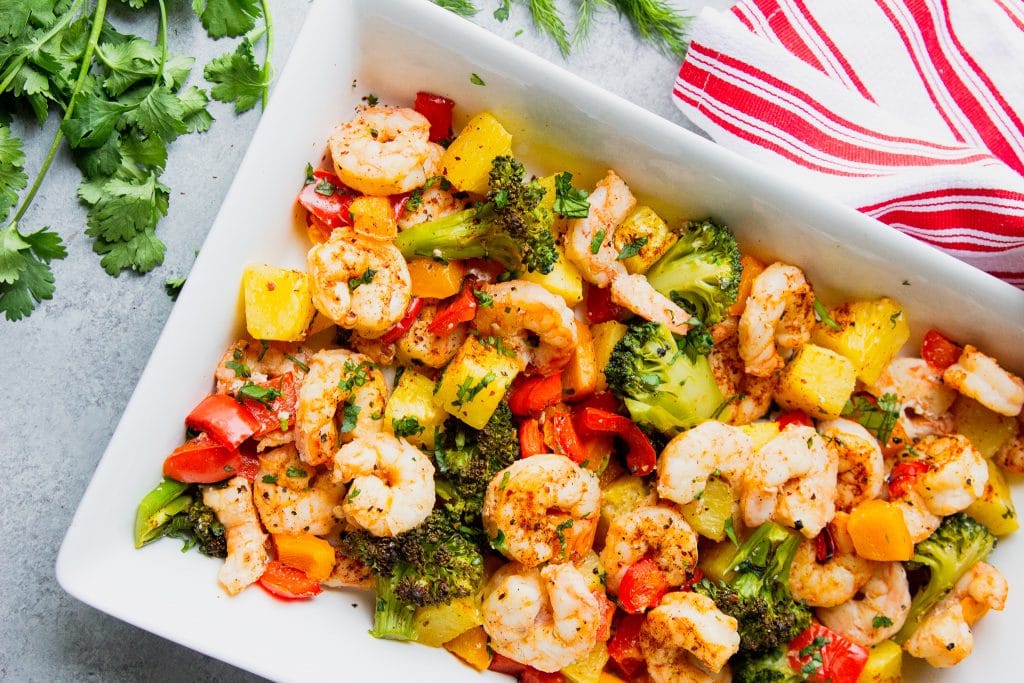 shrimp, broccoli, pineapple and bell peppers on a serving platter