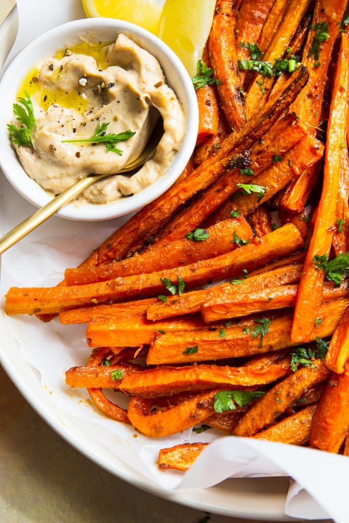 Baked carrot fries, garnished with parsley and served with sriracha mayo