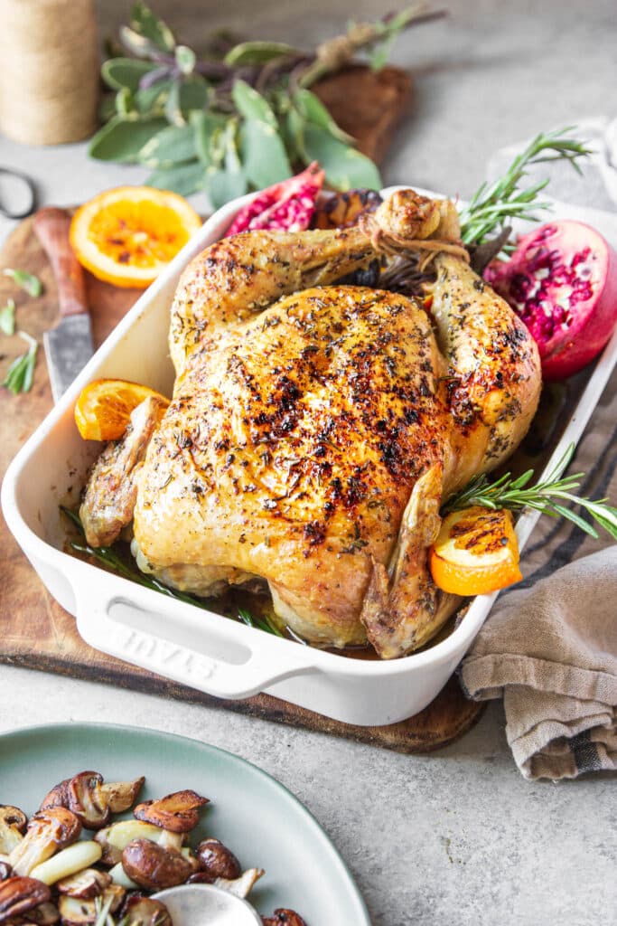 Whole roasted chicken with aromatic herbs and citrusy fruits