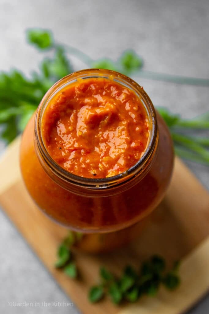 Open jar of tomato sauce made with cherry tomatoes. 