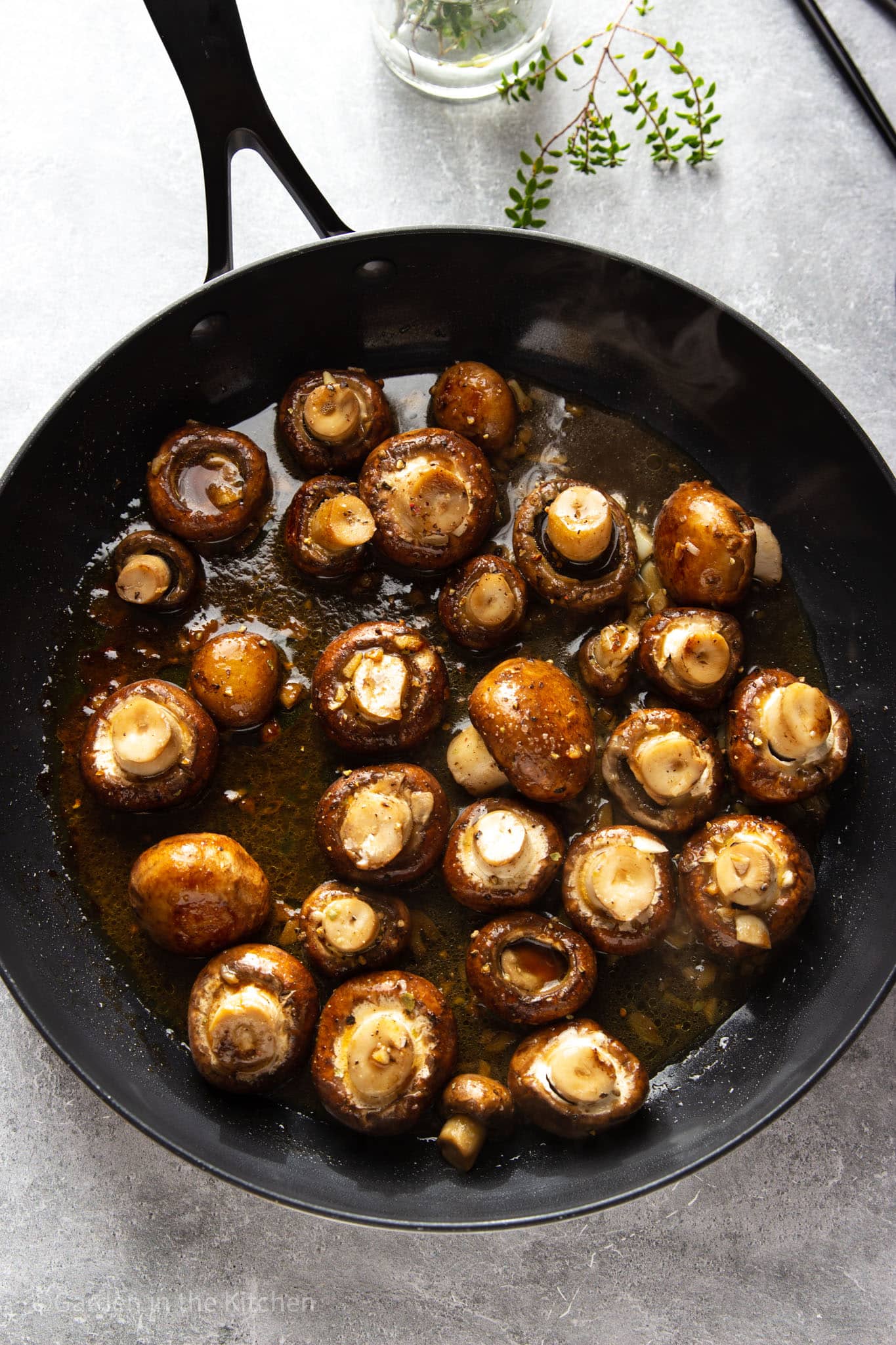 Mushrooms cooked a a black skillet. Image shows that mushrooms release water and therefore additional liquid is not needed. 