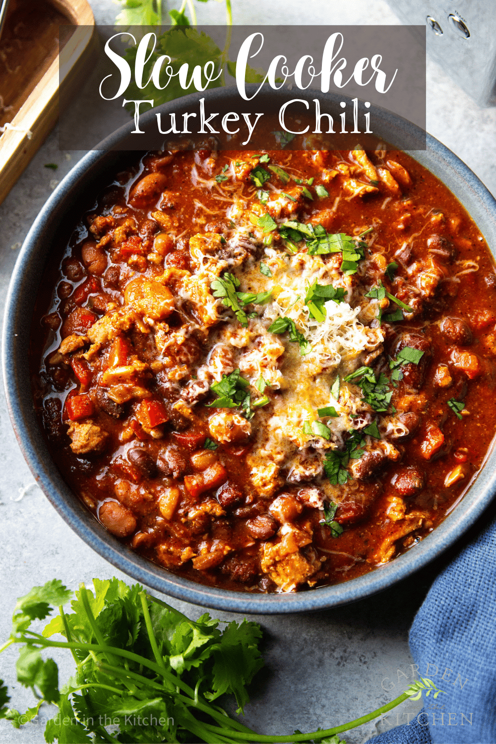 Slow cooker turkey chili recipe served in a bowl with cheese. 