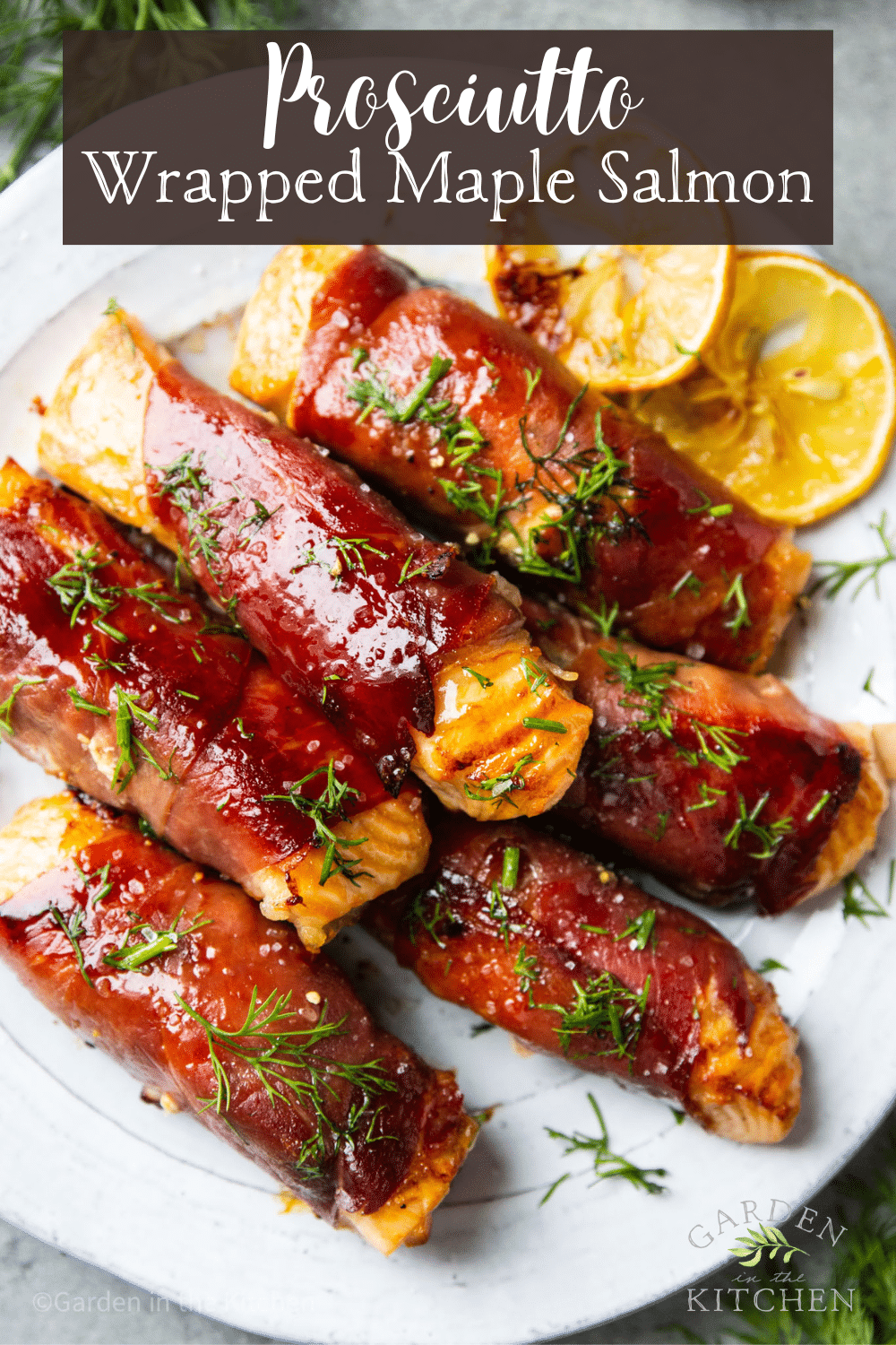 pinterest image of prosciutto wrapped salmon filets piled on top of each other on a white plate.