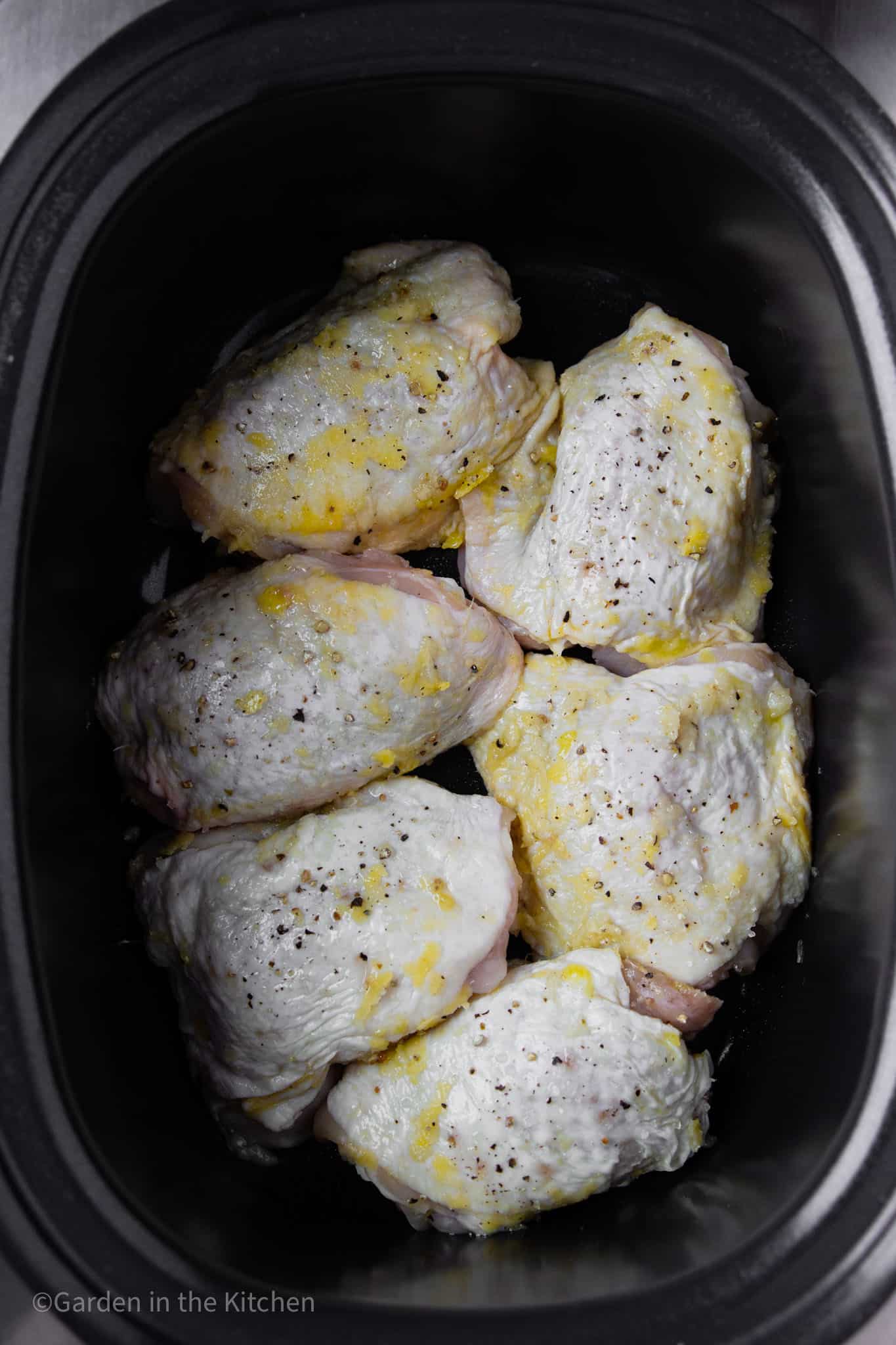 raw chicken thighs in a large slow cooker.