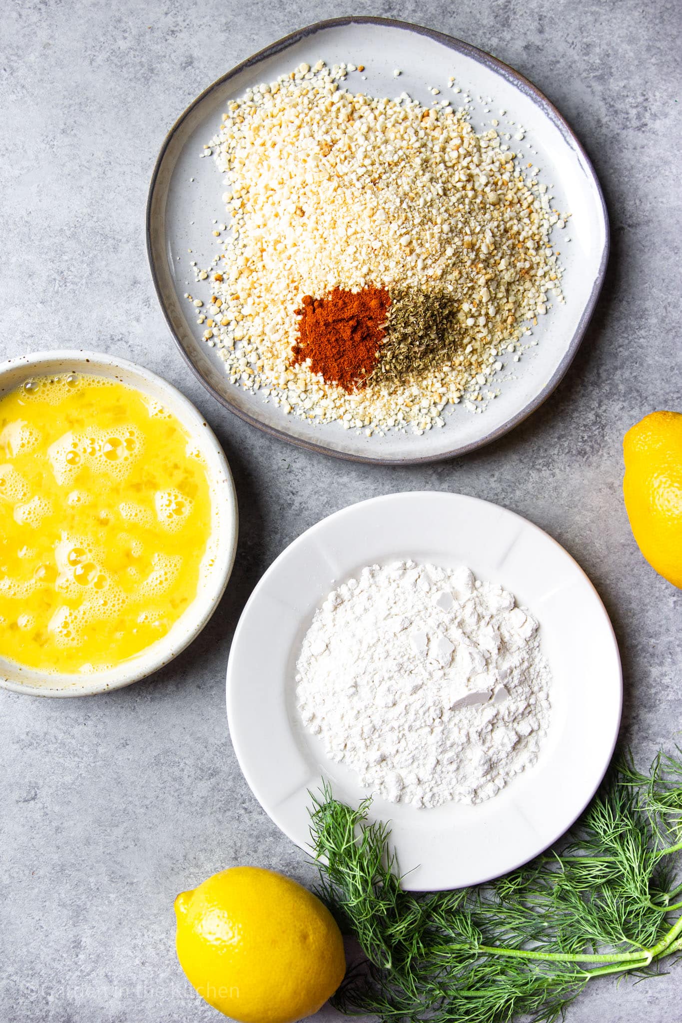 flour, breadcrumbs, and beaten eggs in 3 different white bowls.