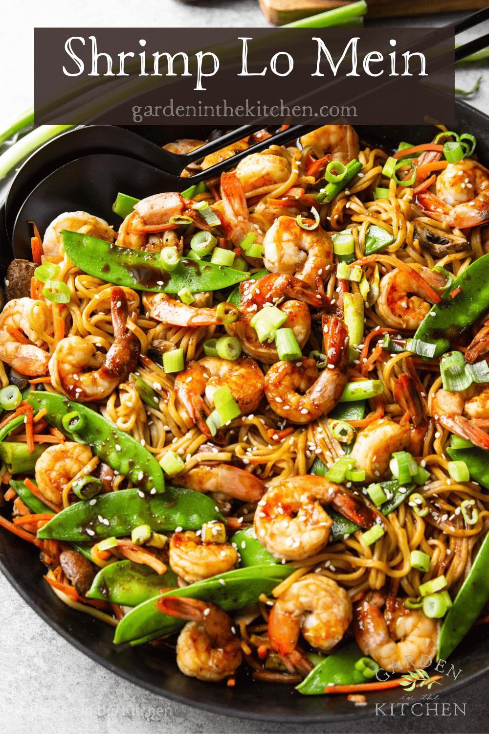 pinterest image of shrimp lo mein topped with scallions in a large black skillet.