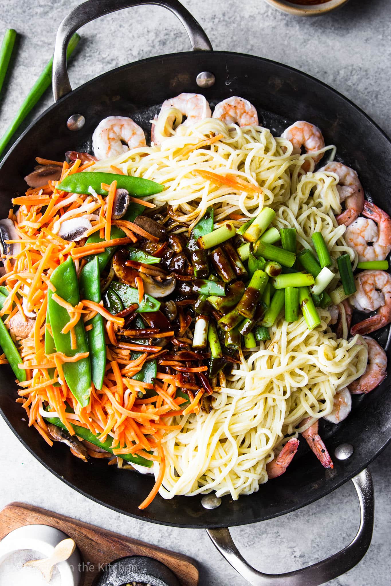 the ingredients for shrimp lo mein in a large black skillet.
