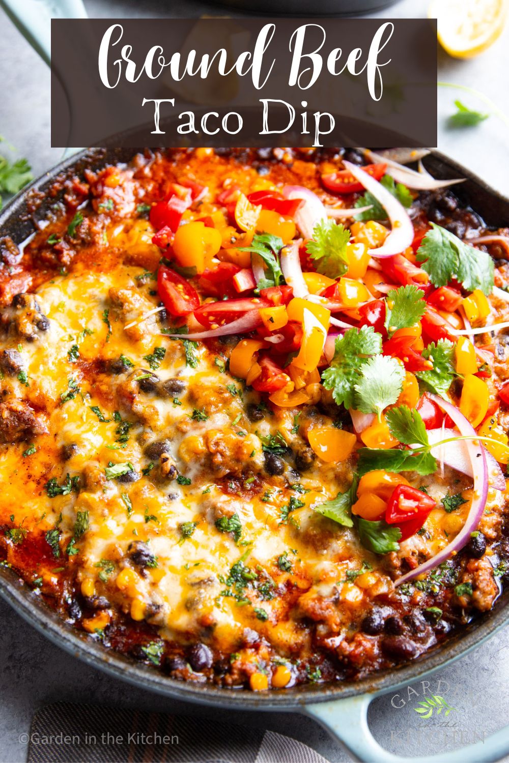 pinterest image of ground beef taco dip in a black skillet topped with tomato salsa.