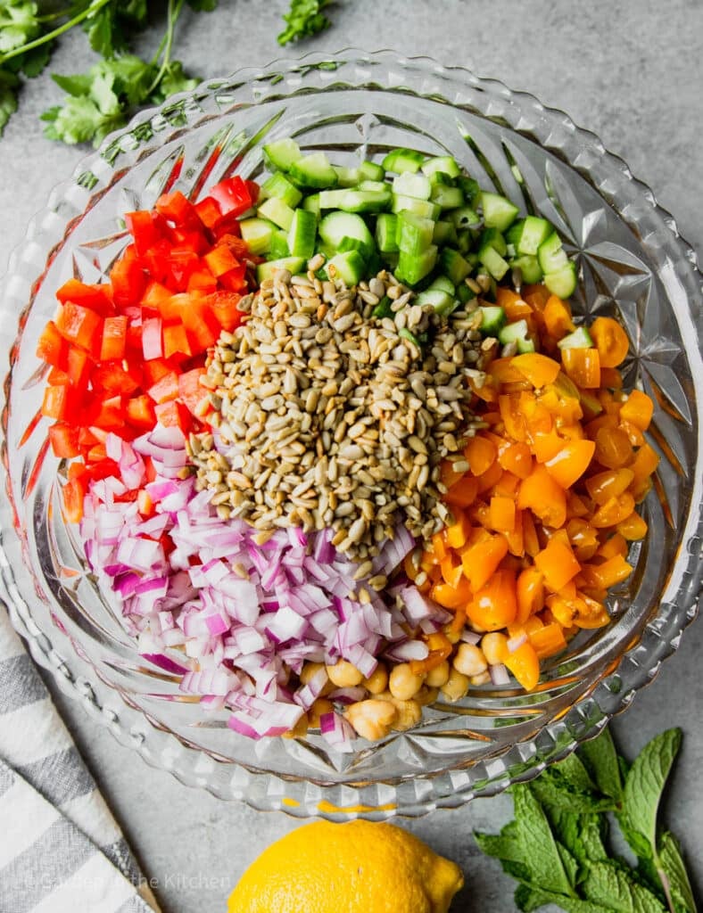 ingredients for chickpea salad in a large glass bowl.
