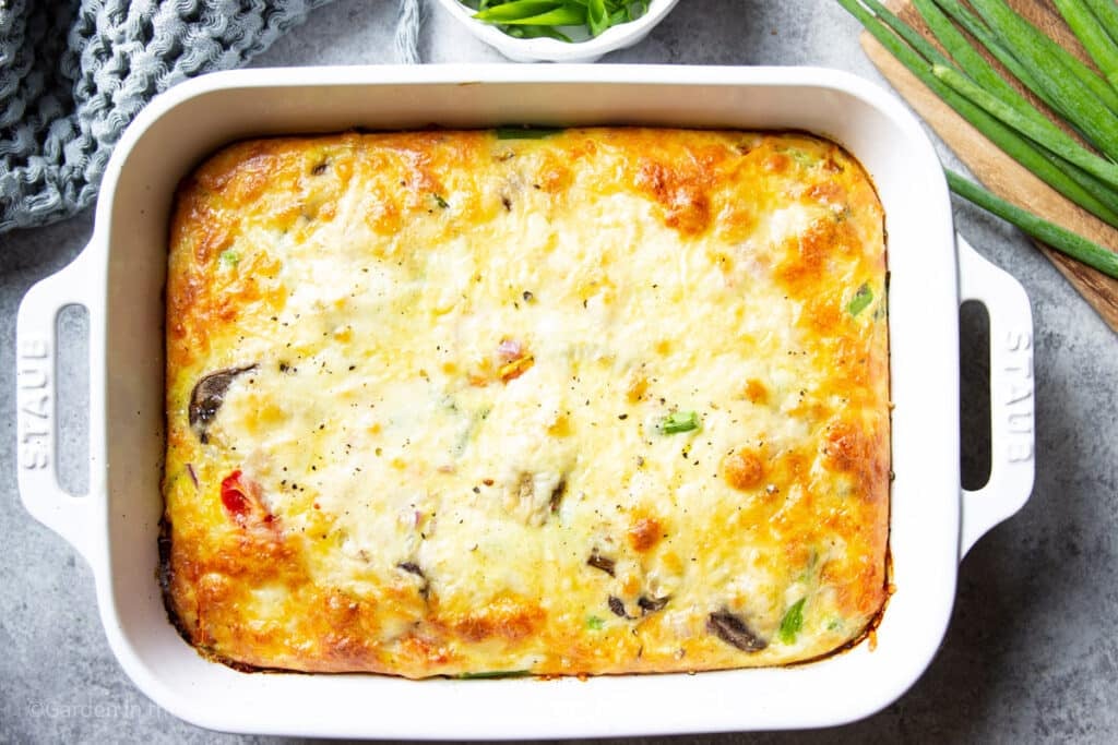 a baked farmer's casserole in a white baking dish.