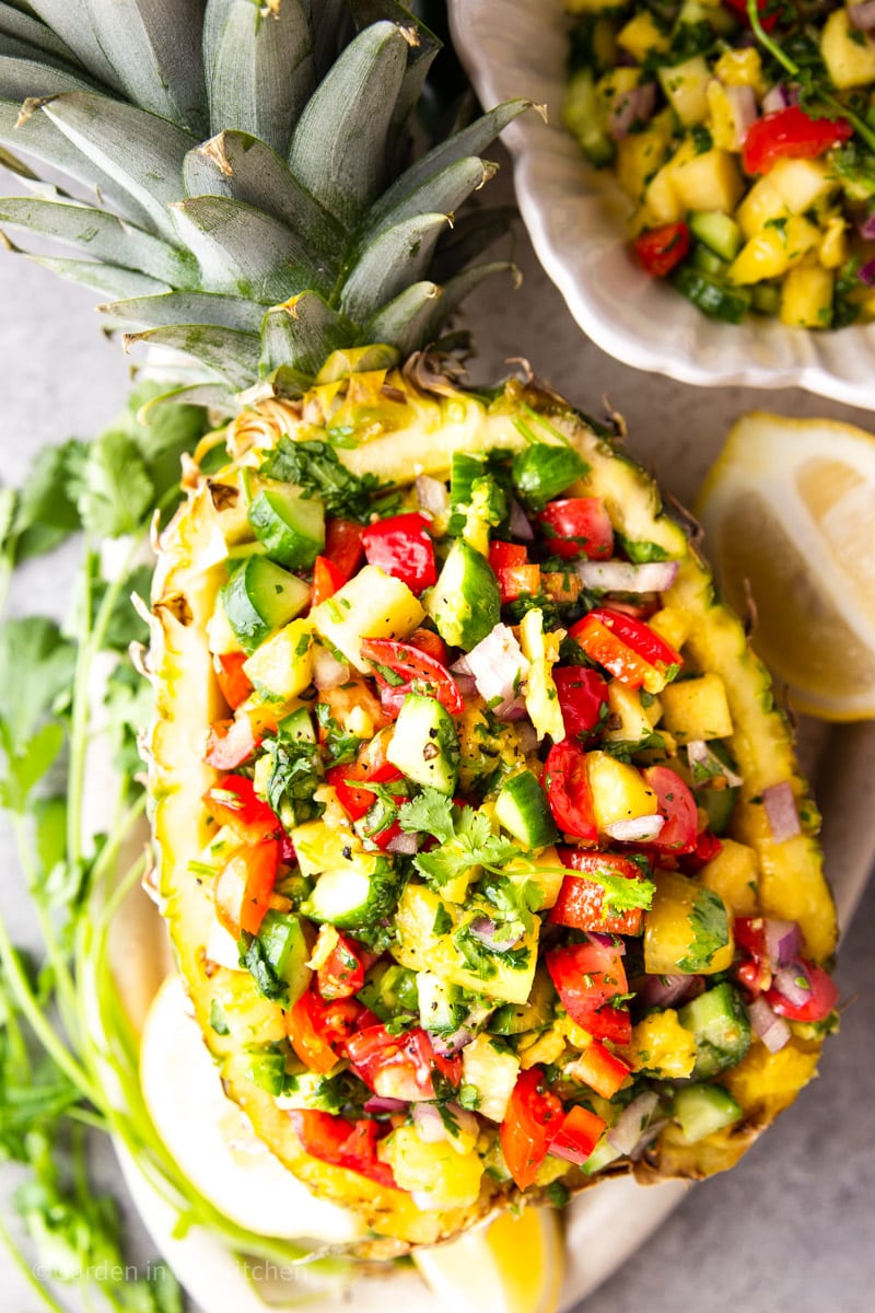 Pineapple salsa served in the Pineapple with crown. Lemons, cilantro and jalapeño on the side.