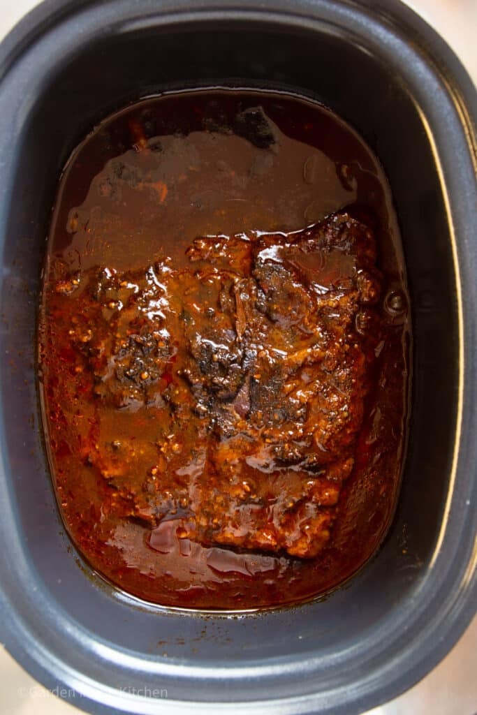 Cooked brisket in barbeque sauce in the slow cooker.