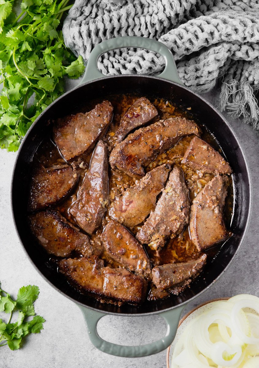 Liver in a pan with cilantro, onions and scarf. 