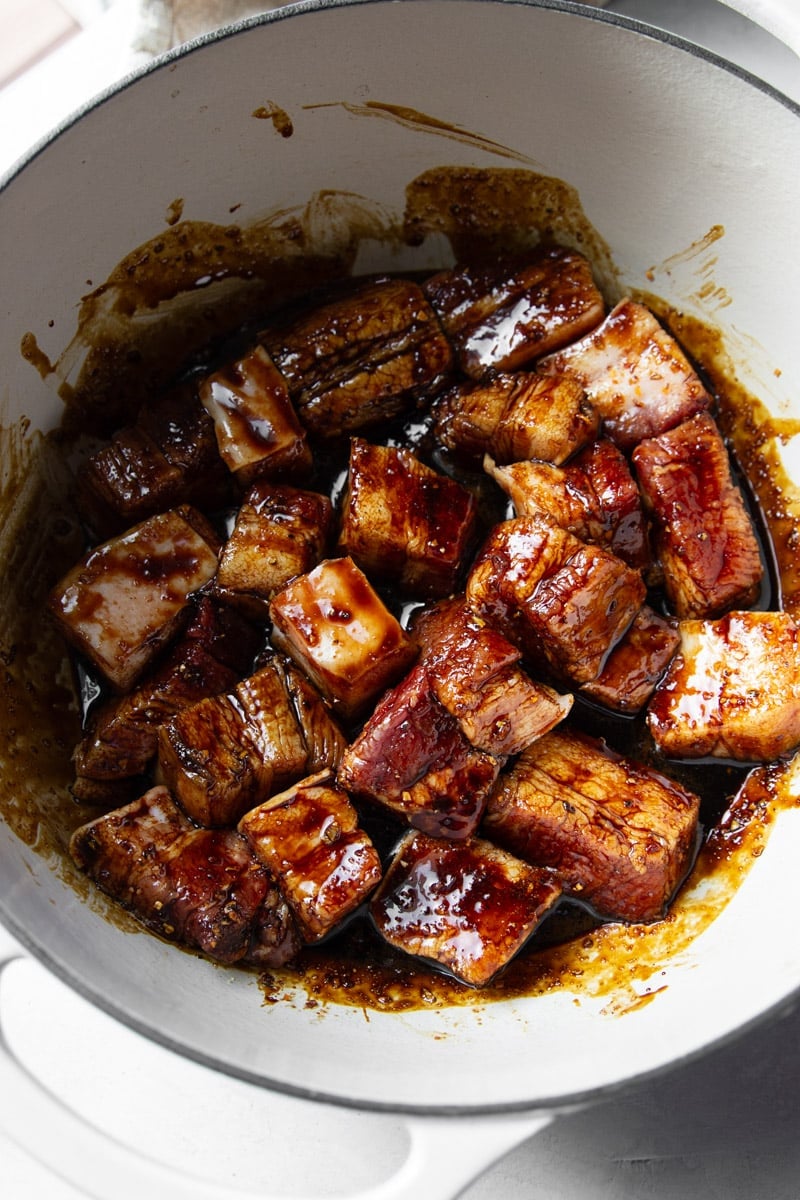 Diced pork belly that's seasoned with the sugar and coconut aminos in a white bowl.