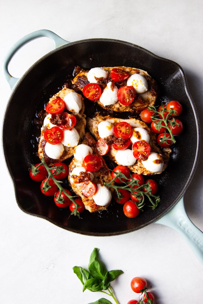 Chicken with fresh mozzarella and tomatoes on the vine, basil. 
