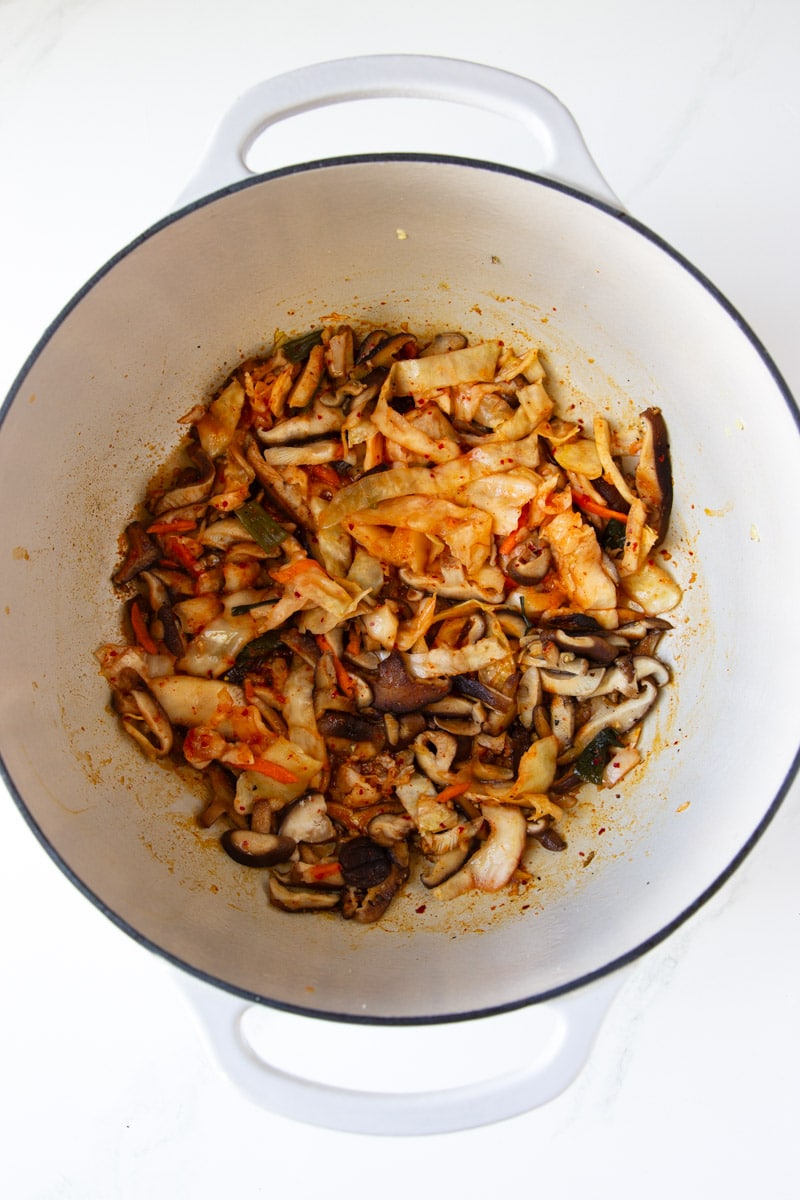 Shiitake mushrooms and kimchi in a white pot. 