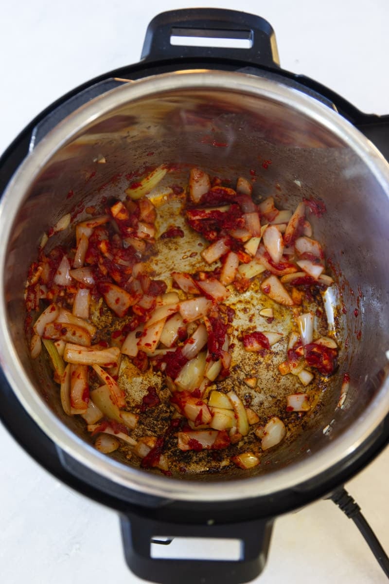 Onions garlic and tomato paste in the instant pot. 