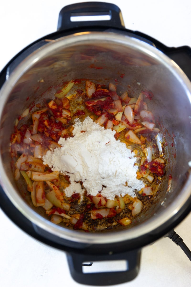 Onions, garlic, tomato paste and flour in the instant pot. 