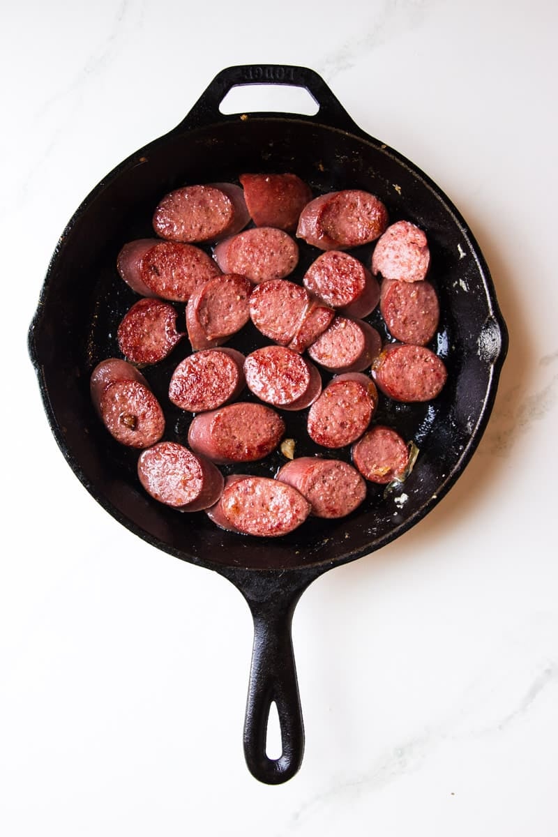 Browning the kielbasa in a cast iron skillet. 