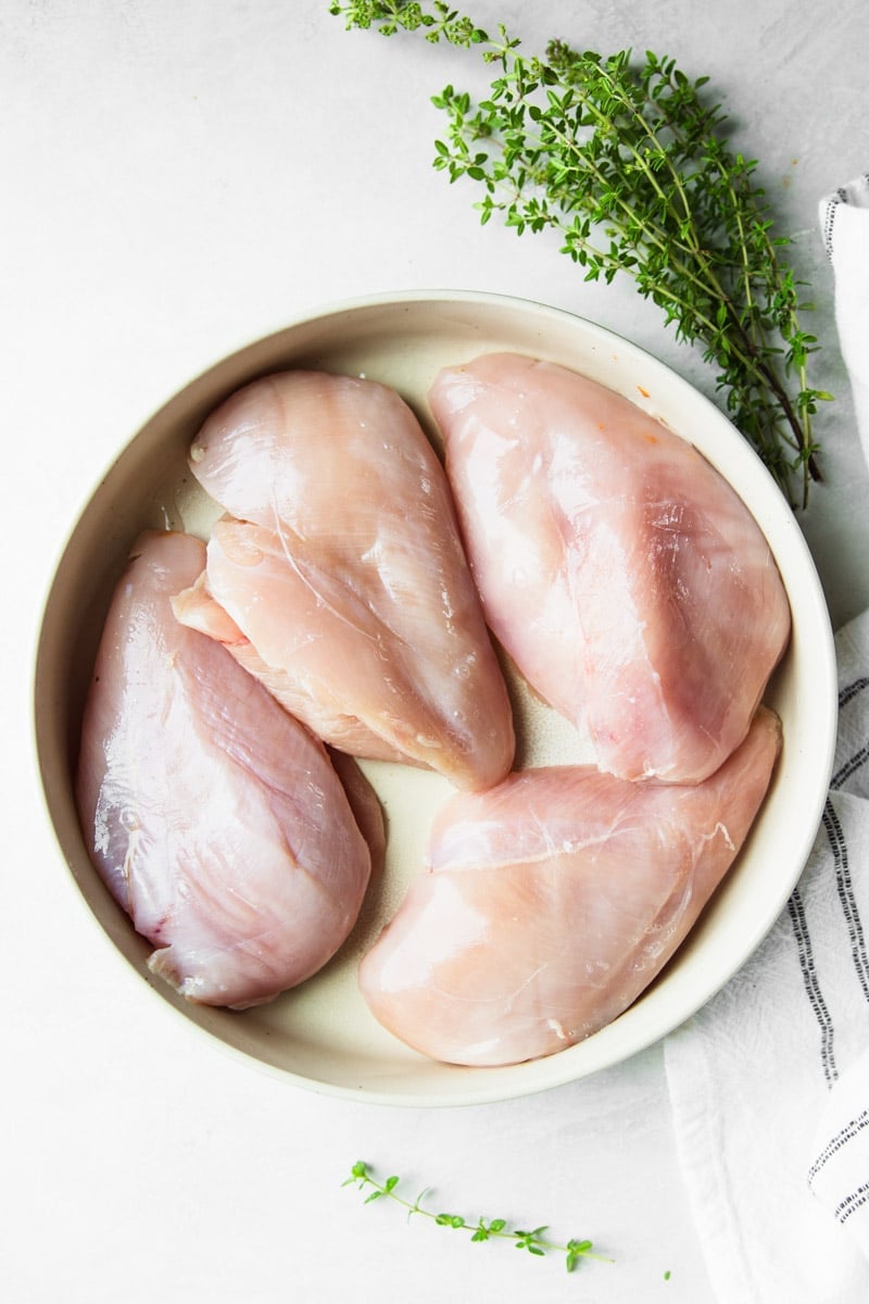 Fresh thyme, raw chicken, white and black dish towel,