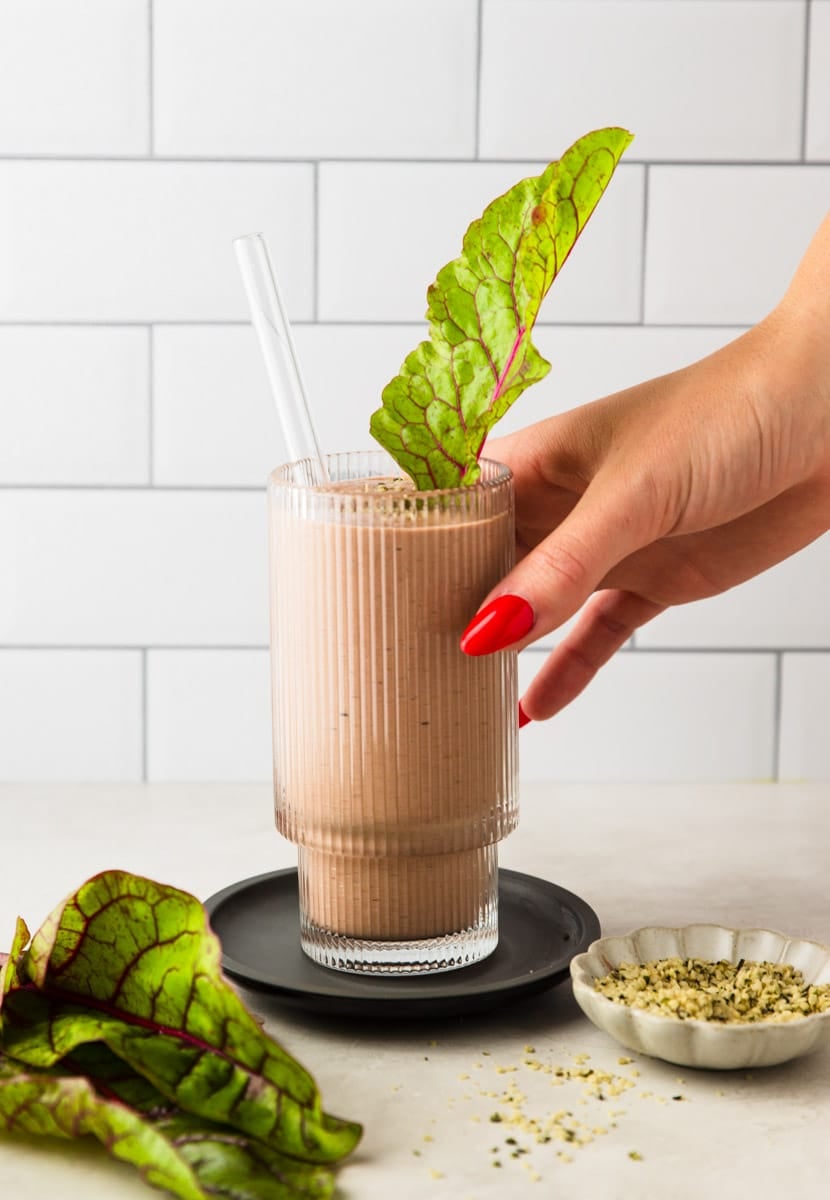 Swiss Chard Raspberry Kefir Protein Smoothie, hemp seeds in a white bowl, Swiss chard leaves.