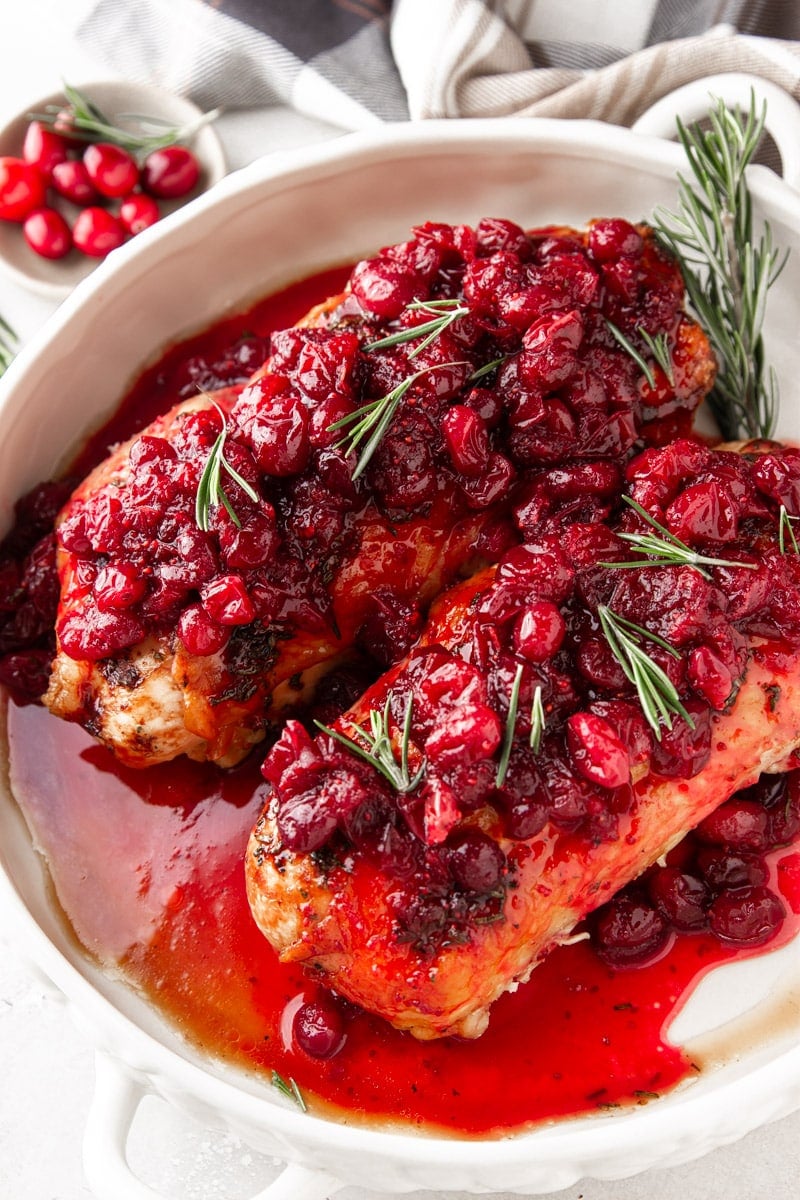 Plaid dish towel, cranberries, fresh rosemary, cranberry glazed turkey breasts.