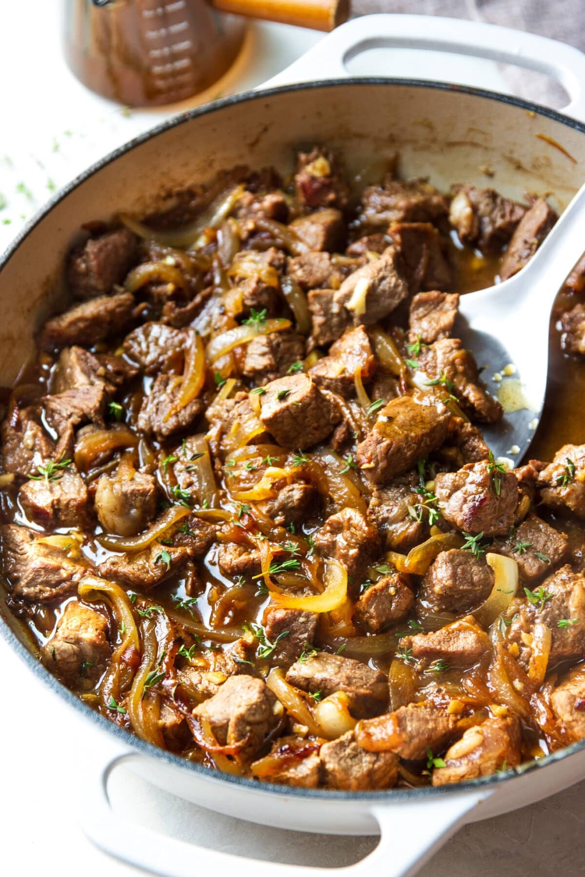 steak bites in a skillet with spatula