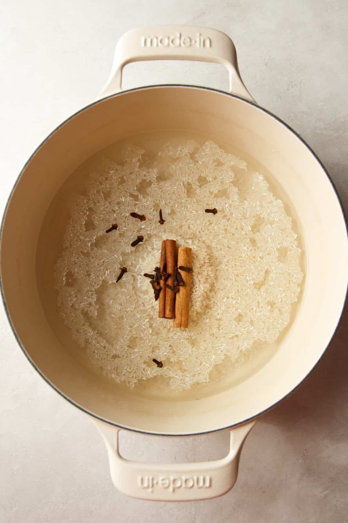 rice, cinnamon sticks and cloves in a pot with water