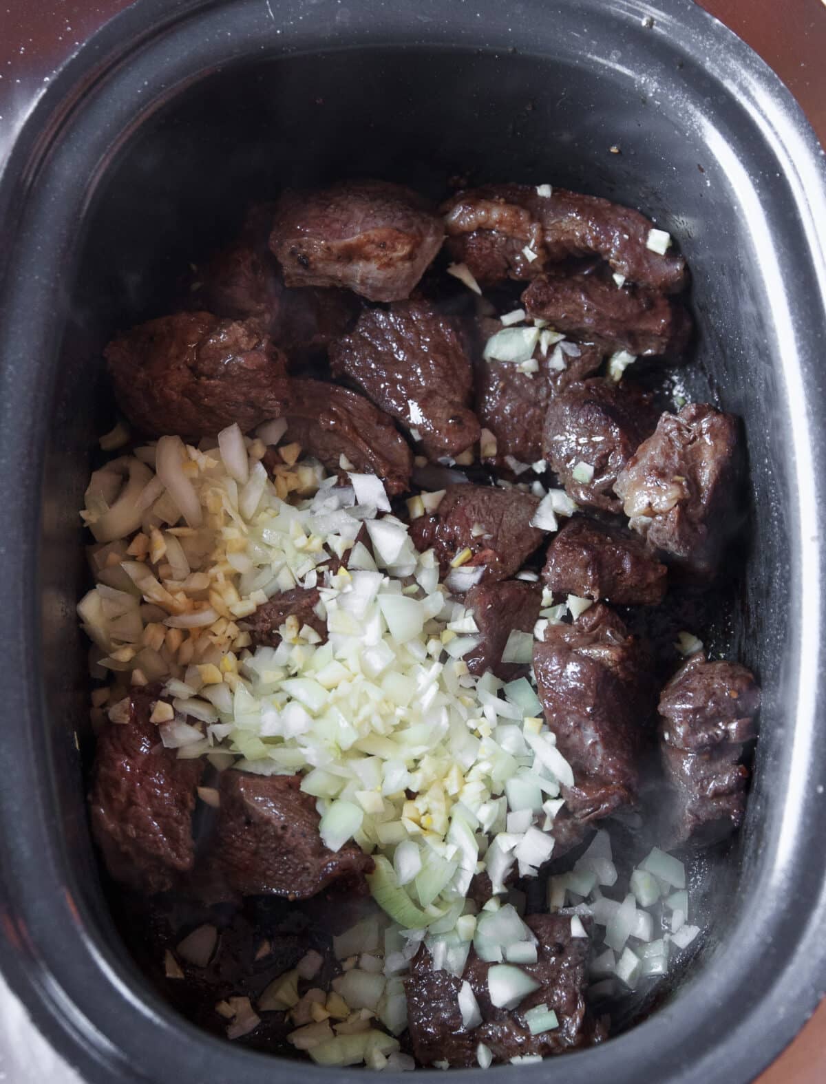 Slow Cooker Hot Honey Chili Beef made with tender beef chuck, chili crunch, garlic, and a rich sweet-spicy sauce. Easy to make and perfect over rice.