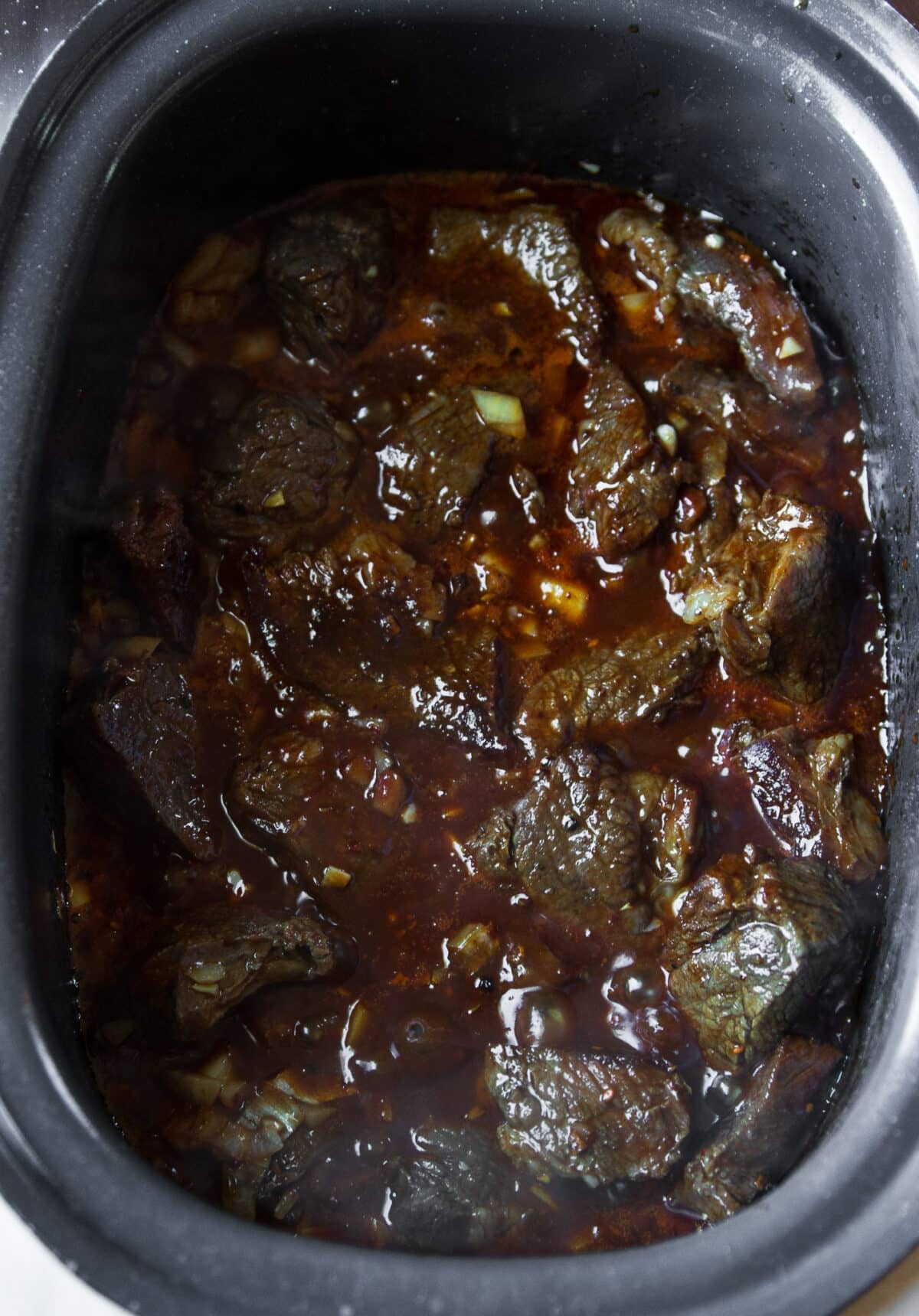 Slow Cooker Hot Honey Chili Beef made with tender beef chuck, chili crunch, garlic, and a rich sweet-spicy sauce. Easy to make and perfect over rice.