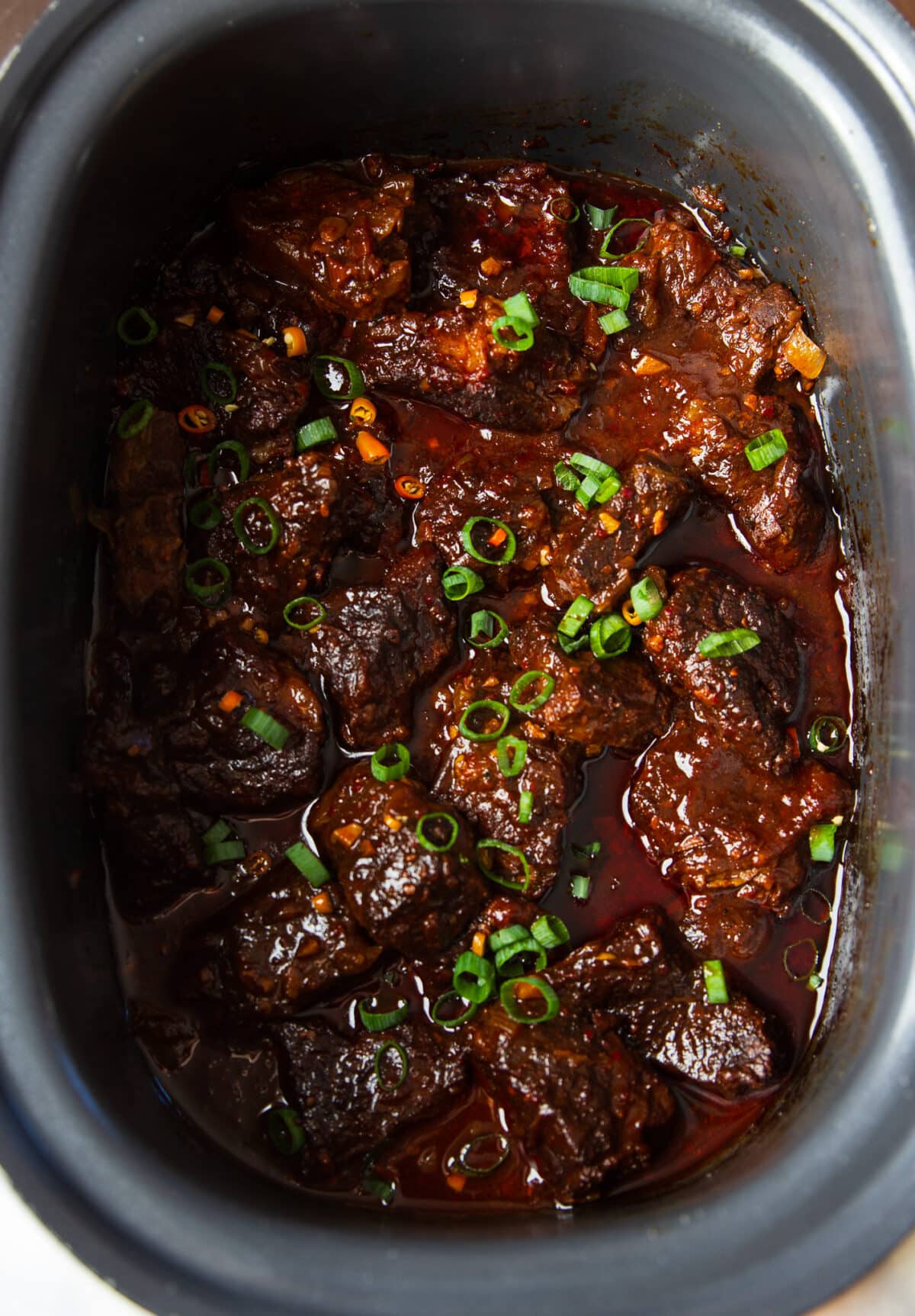 Slow Cooker Hot Honey Chili Beef made with tender beef chuck, chili crunch, garlic, and a rich sweet-spicy sauce. Easy to make and perfect over rice.